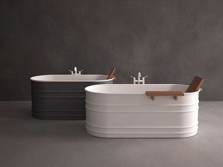 two bath tubs sitting next to each other on top of a gray flooring