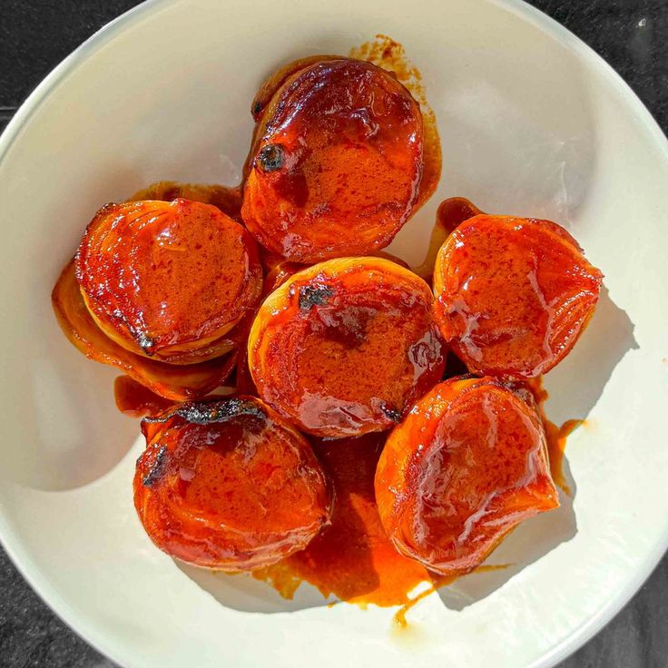 a white bowl filled with food covered in sauce