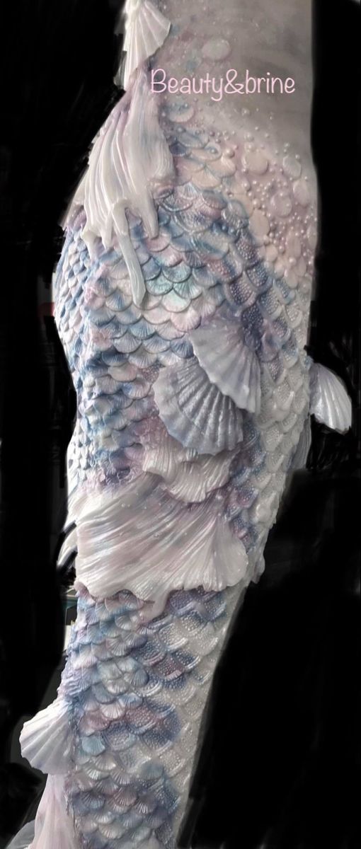 a woman's dress made out of white and blue fabric with shells on it