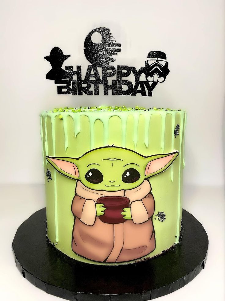 a birthday cake with an image of the baby yoda holding a cell phone in front of it