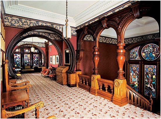 an ornately decorated room with stained glass windows and wooden furniture in the center is shown