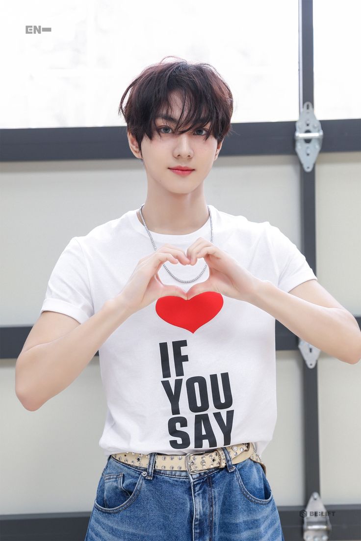 a young man holding a heart shaped object in his hands