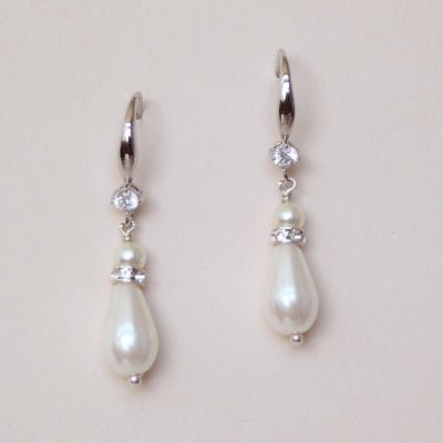 These delicate hanging pearl earrings are an understated yet elegant addition to any look. Details Cubic zirconia ear wires 1 1/2 inches by 1/4 inch Timeless design and suits a range of bridal looks Designed and handmade in our studio Swarovski pearls, faux pearls Please allow 2 weeks for delivery Silver Linear Earrings With Pearl Charm For Wedding, Classic Bridal Dangle Earrings With Pearl Charm, Classic Pearl Linear Drop Earrings, Classic Bridal Earrings With Pearl Charm And Cubic Zirconia, Classic Pearl Earrings With Ear Wire For Weddings, Classic Pearl Hoop Earrings For Anniversary, Classic Pearl Linear Earrings For Wedding, Elegant Hypoallergenic Dangle Bridal Earrings, Hypoallergenic Pearl White Pearl Earrings For Wedding