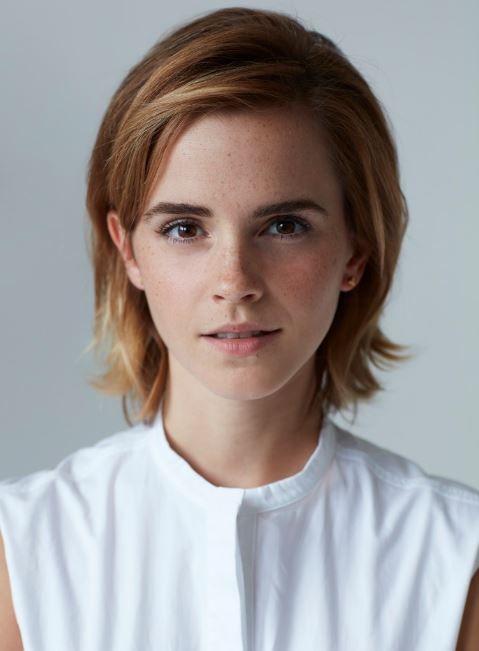 a close up of a person wearing a white shirt and looking at the camera with a serious look on her face