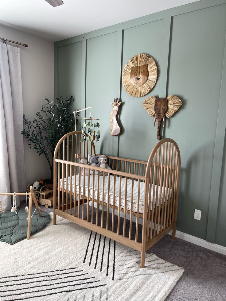 a baby's crib in the corner of a room with green painted walls