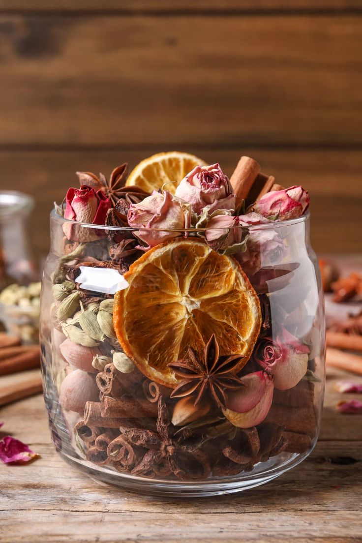 a glass jar filled with dried orange slices and spices