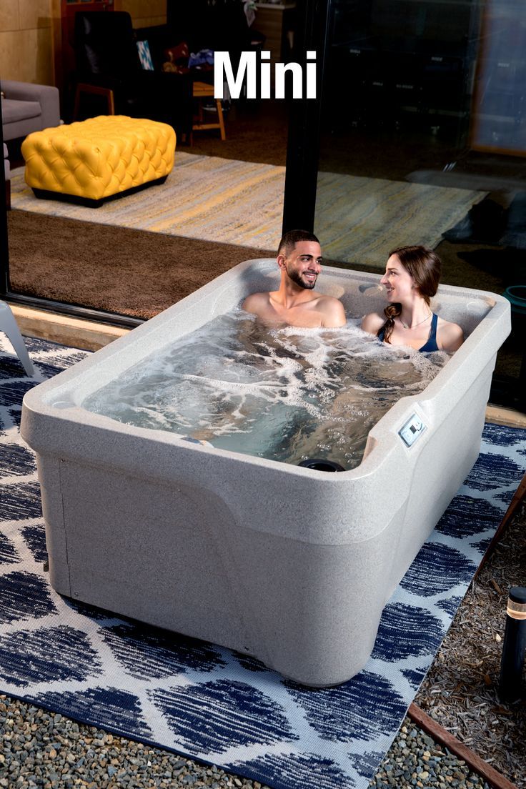 a man and woman sitting in an outdoor hot tub with the words mini above it