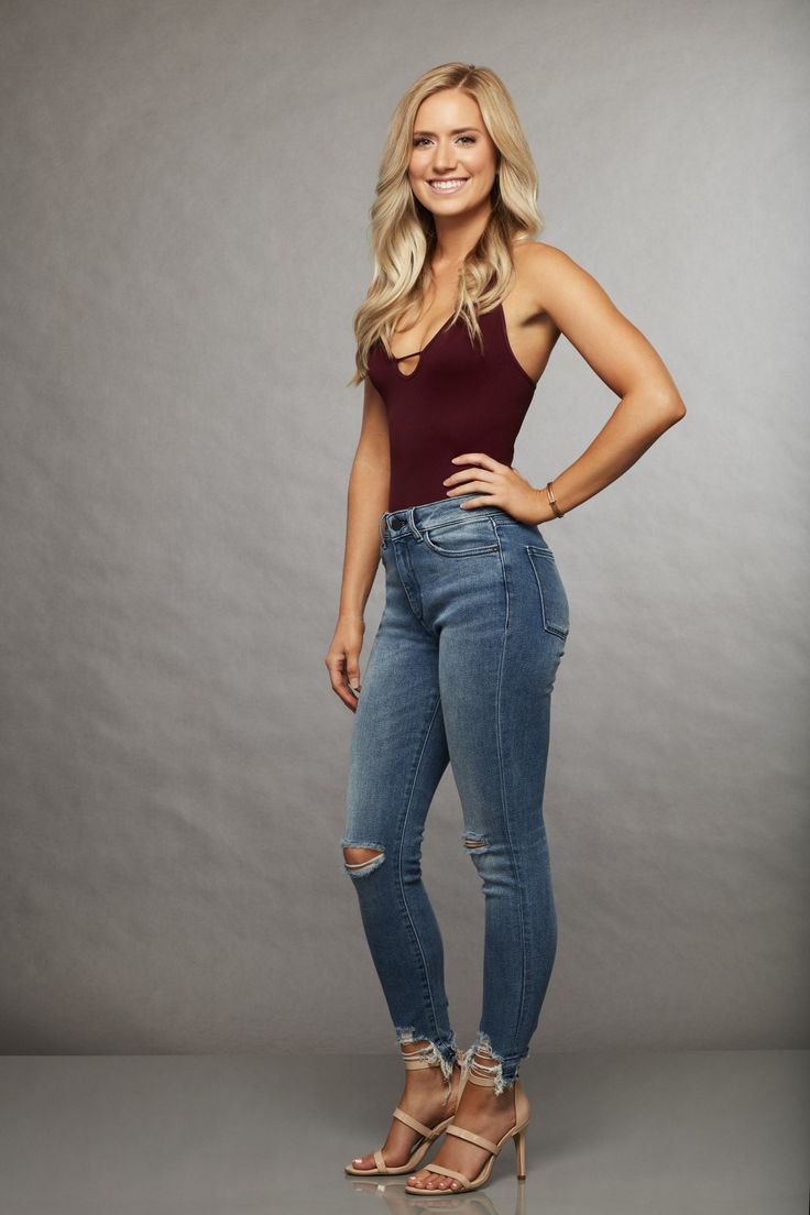 a woman in jeans and heels posing for the camera with her hands on her hips