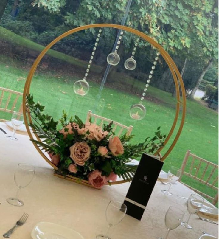 the table is set with wine glasses and flowers