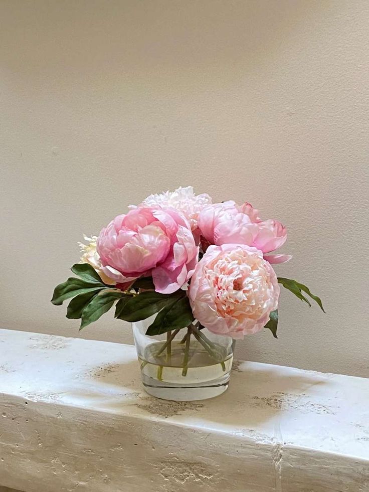 some pink flowers are in a glass vase