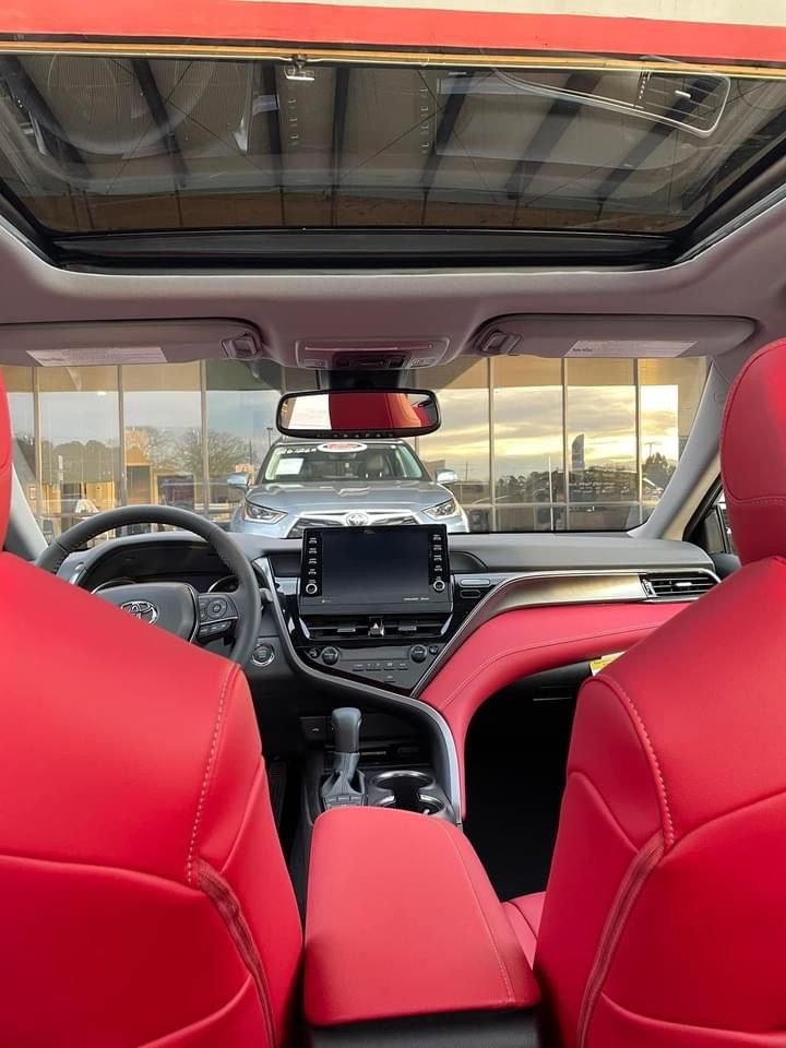 the interior of a car with red leather seats and dash board, including an entertainment center