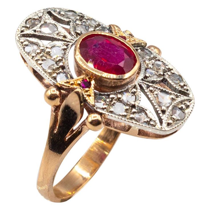 a gold ring with a red stone surrounded by white stones