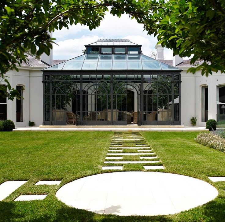 a large white house sitting on top of a lush green field