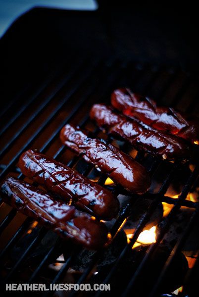 hot dogs are cooking on the grill in the dark