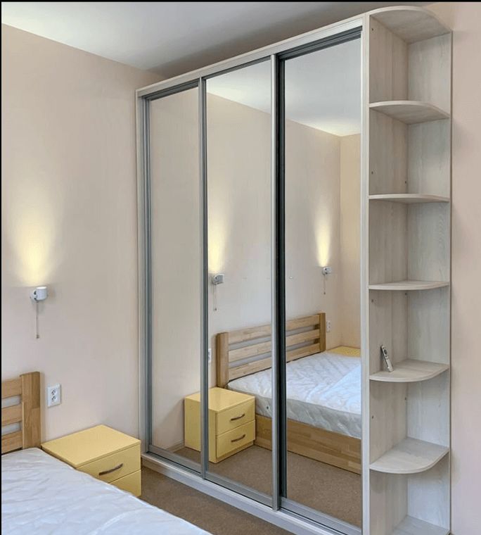 a bed sitting next to a closet in a bedroom