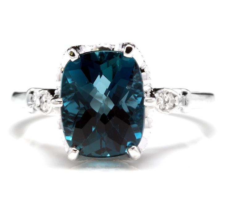 an oval cut blue topazte and diamond ring with two white diamonds around it