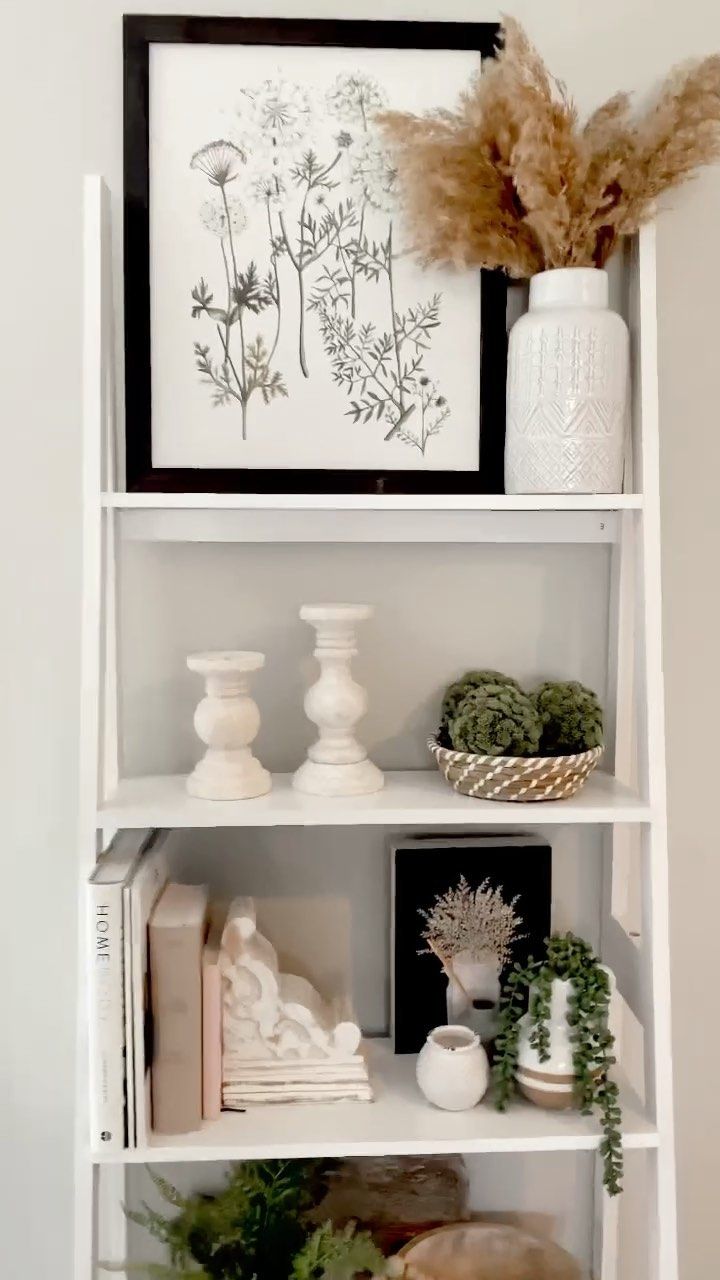 a white shelf filled with vases and plants