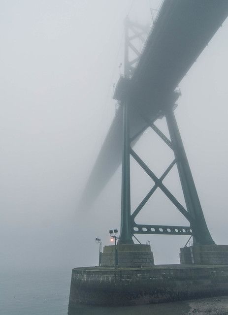 a foggy view of the top of a bridge