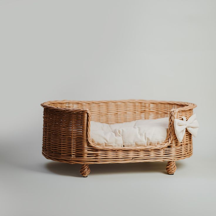 a wicker baby bed with a white pillow in it's back and side