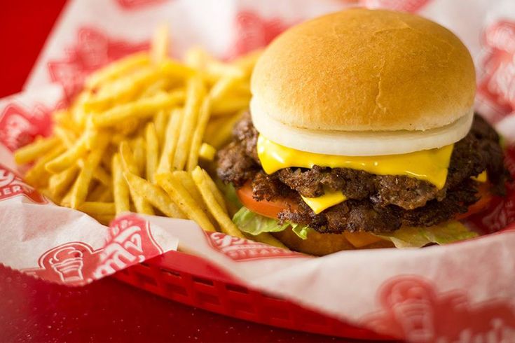 a cheeseburger and fries in a basket on a table