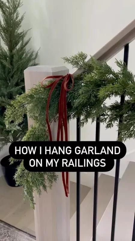 the stairs are decorated with christmas greenery and red ribbon, which reads how i hang garland on my railings