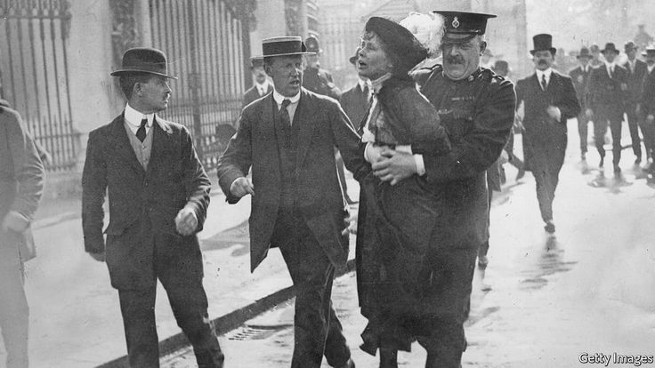 an old black and white photo of men walking in the rain