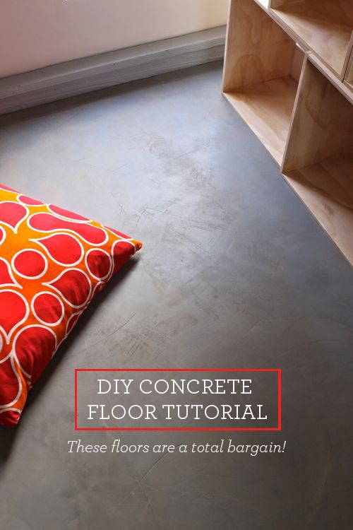 a red and orange pillow sitting on top of a floor next to a book shelf