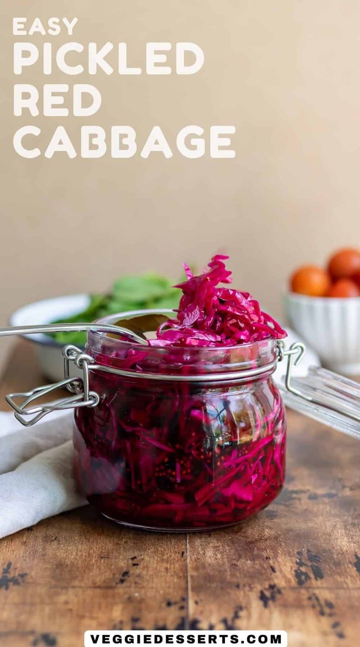 a jar filled with red cabbage sitting on top of a wooden table