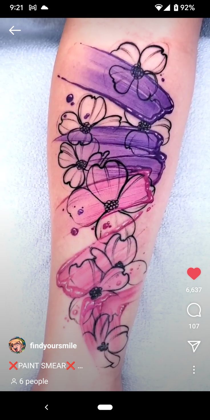 a colorful tattoo with flowers on the side of her leg and an arrow in the middle