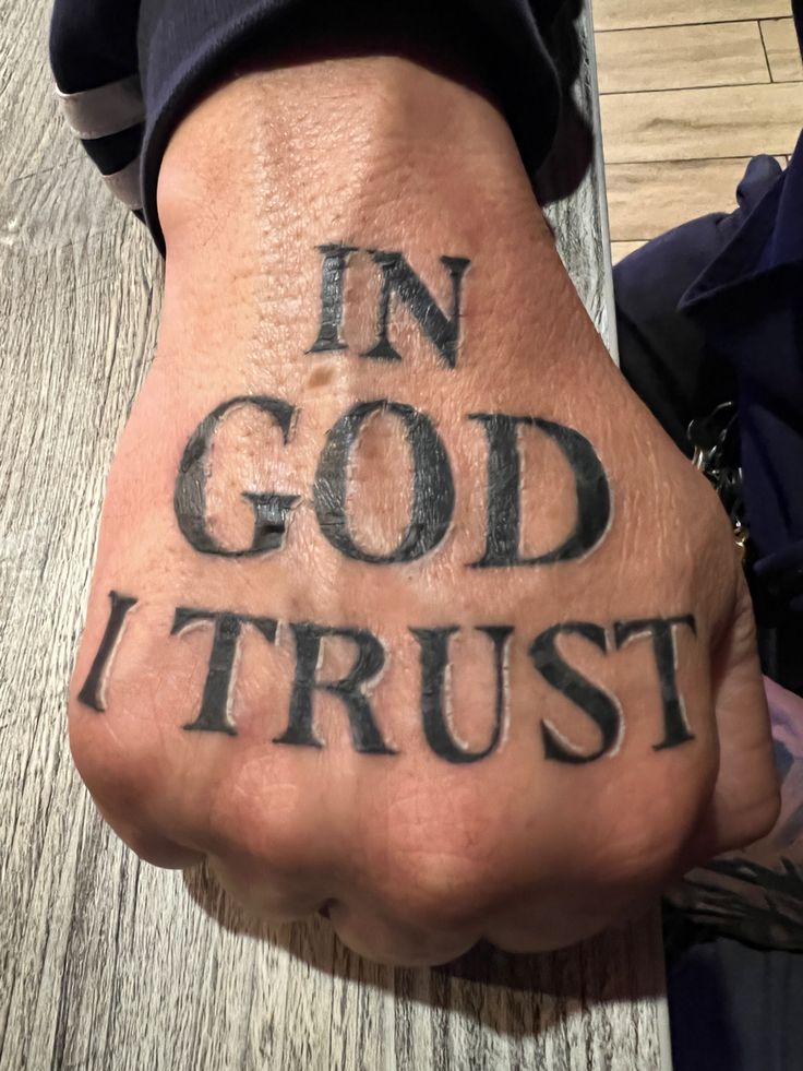 a hand with the words in god trust written on it