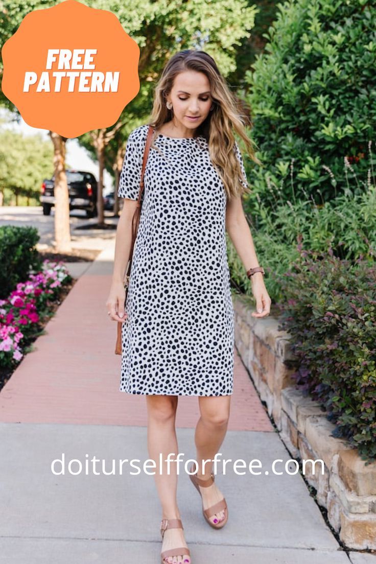 a woman walking down a sidewalk wearing a dress with an animal print pattern on it