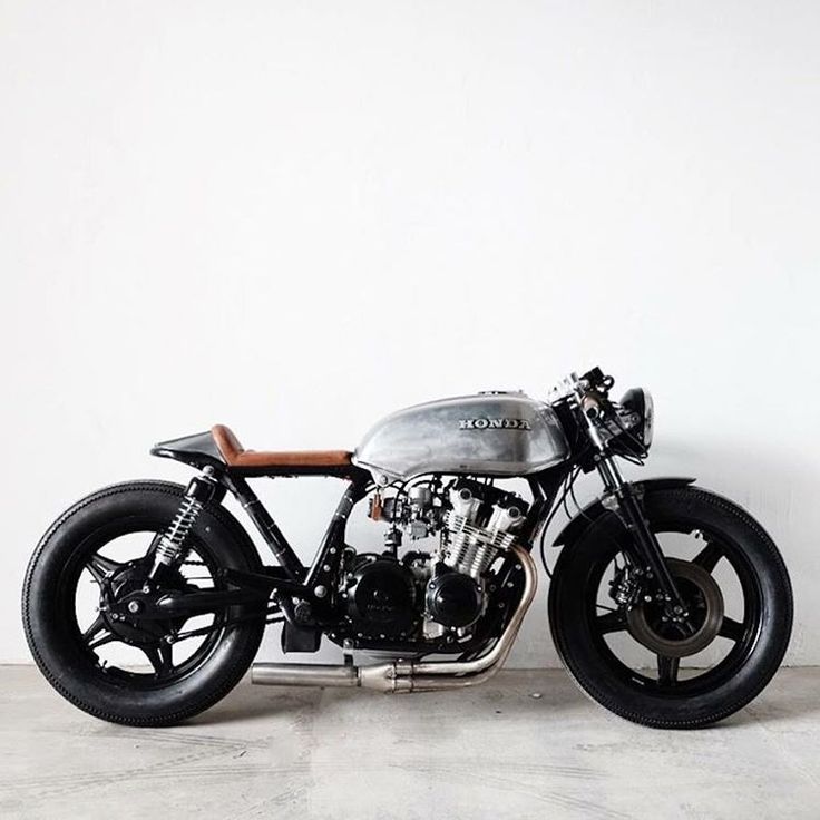 a silver motorcycle parked in front of a white wall