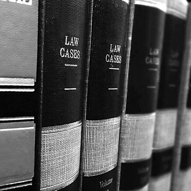 black and white photograph of law cases in a row on the shelf next to each other