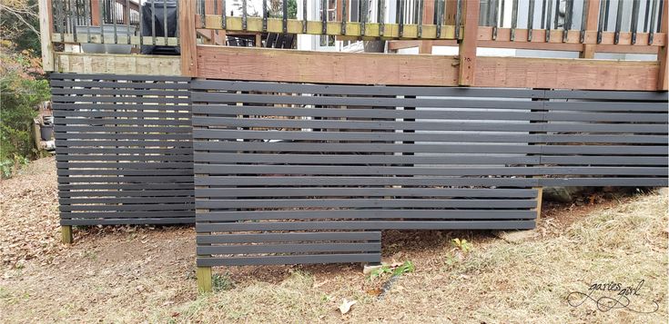 two wooden slats sitting on the side of a hill in front of a house