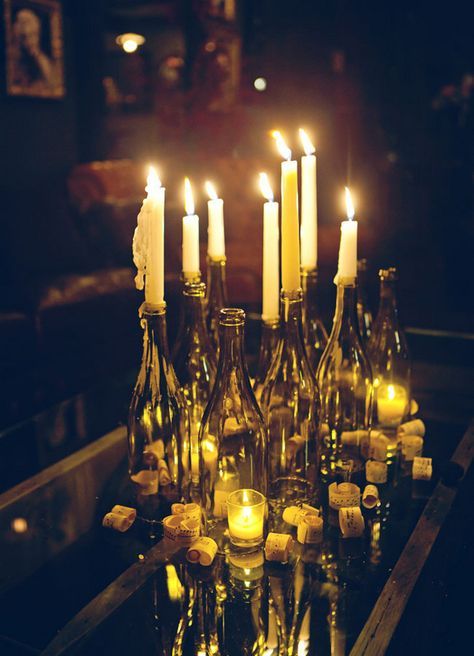 a table topped with lots of bottles filled with candles