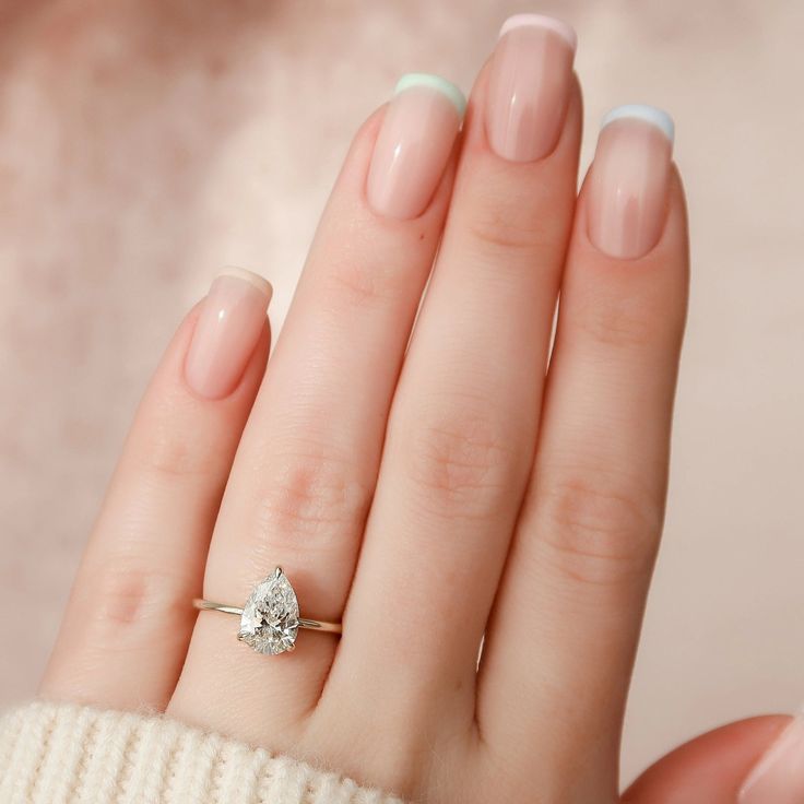 a close up of a person's hand with a ring on their finger and a diamond in the middle