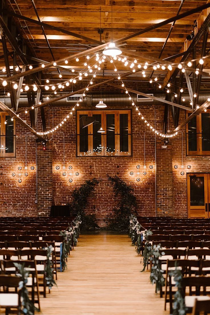 an indoor venue with rows of chairs and string lights