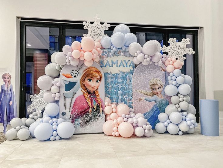 there is a frozen princess balloon arch in front of the store window with balloons all around it