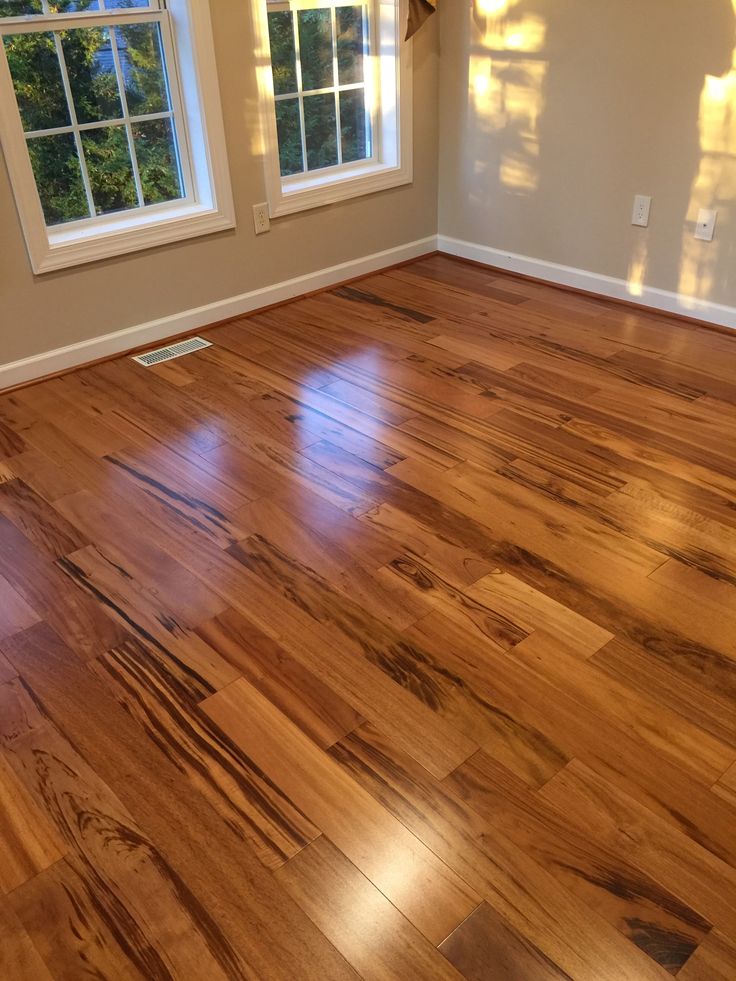 an empty room with hard wood floors and windows