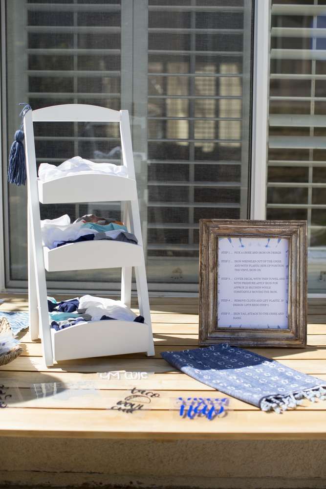 a white chair sitting on top of a wooden table next to a framed photo and other items