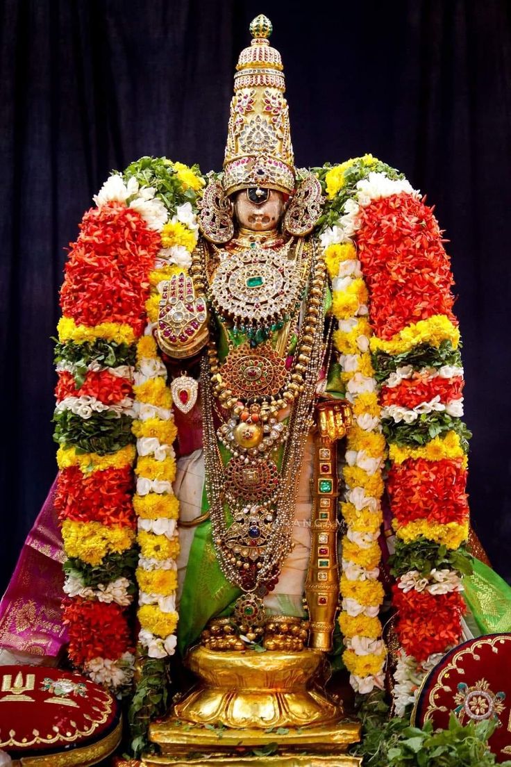 the statue is decorated with flowers and garlands