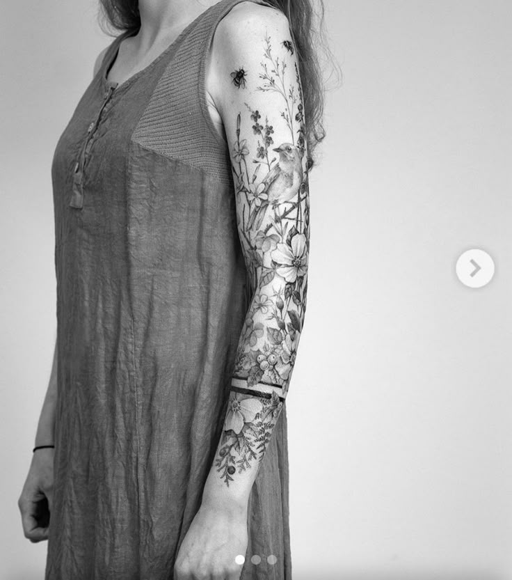 a woman with tattoos on her arm holding a tennis racquet