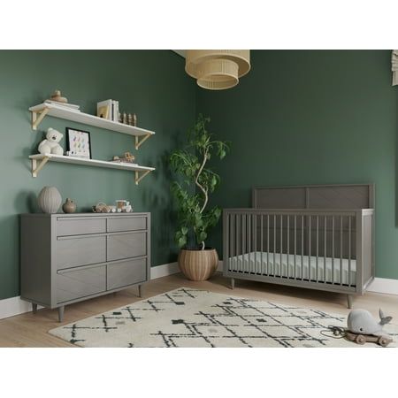 a baby's room with green walls and white rugs on the floor next to a gray crib