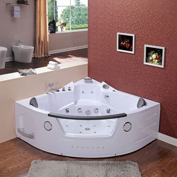 a large white bath tub sitting on top of a wooden floor