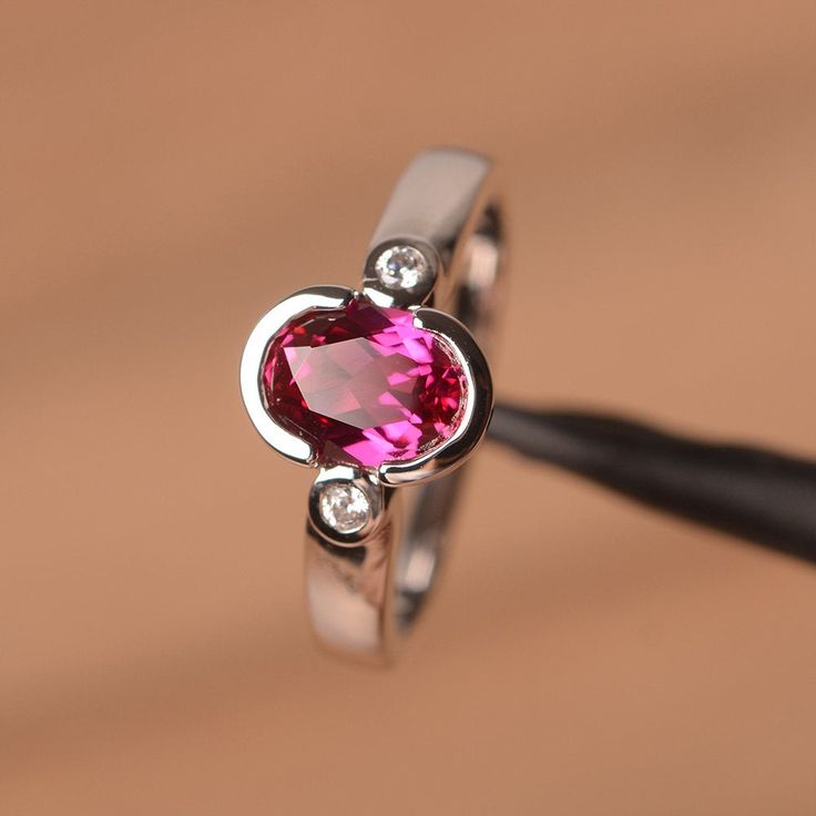 a close up of a ring with a pink stone