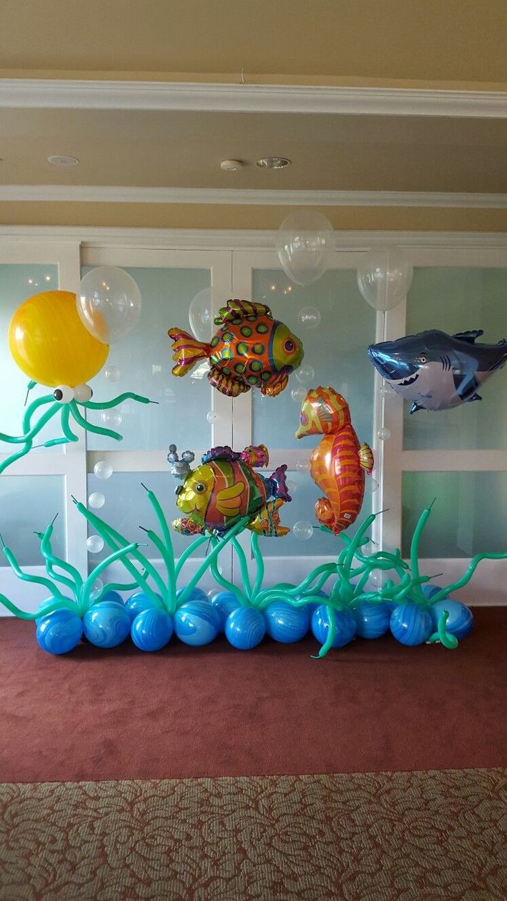 an ocean themed birthday party with balloons and sea animals on the wall, under water