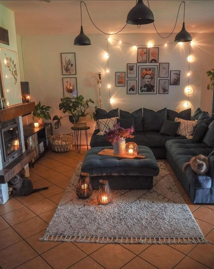 a living room filled with lots of furniture and lights on the wall above it's fireplace