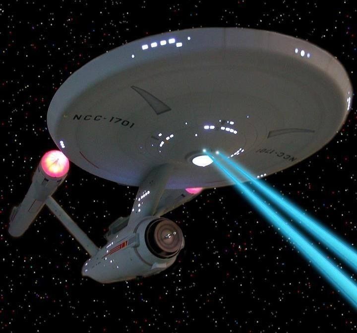 a star trek ship flying through the sky with two laser beams in front of it