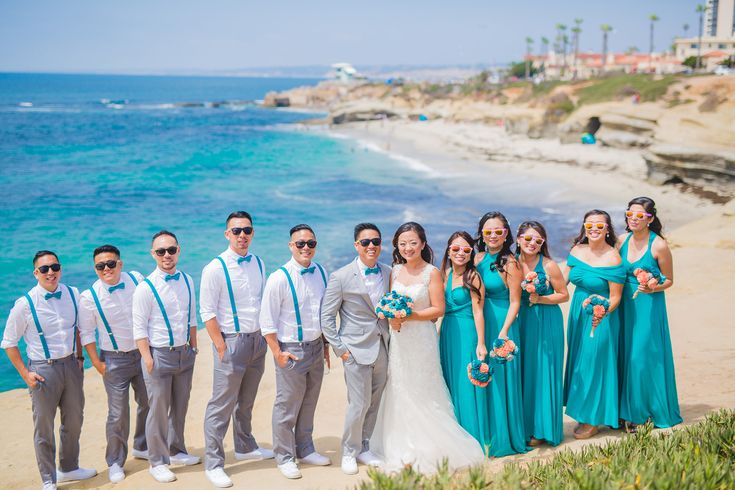 a group of people standing next to each other near the ocean