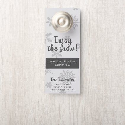 a door hanger with the words enjoy the snow on it and a silver ball